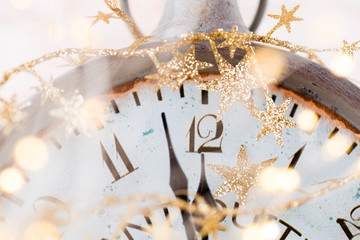 vintage alarm clock is showing midnight. It is twelve o'clock, christmas and bokeh, holiday happy...