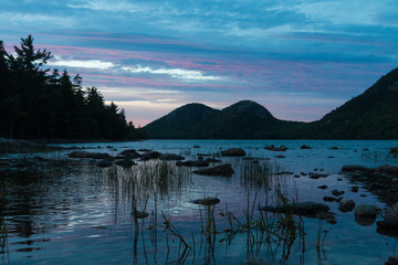 A landscape view of Jordan Pond during sunset in Acadia National Park in Maine.