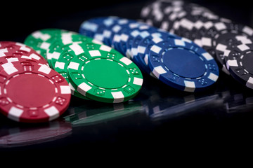 Selective focus on colorful casino chips on dark background