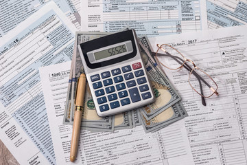 Tax form with dollar, calculator and pen