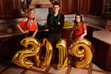 New 2019 Year is coming. Group of cheerful young people carrying gold colored numbers and have fun at the party
