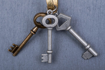 Old vintage metallic keys an natural stone background