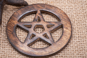 Wooden encircled pentagram symbol on burlap background.. Five elements: Earth, Water, Air, Fire,...