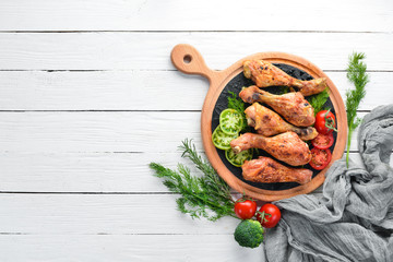 Baked Chicken legs on a white wooden background. Meat. Top view. Free copy space