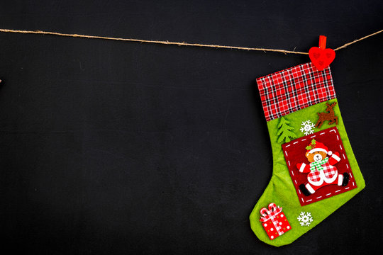 Decorative christmas socks. Empty socks for gift hanging off a thread on black background top view copy space