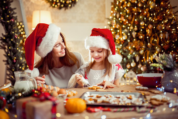 Fototapeta na wymiar Merry Christmas and Happy Holidays. Family preparation holiday food. Mother and daughter cooking Christmas cookies.