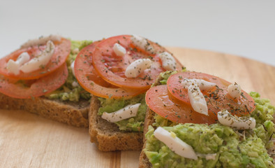 Close up of tomato avocado toast. Healthy eating, healthy breakfast, diet food concept. Front view