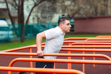 Muscular Man Swinging Press In Playground. Crossfit Concept.