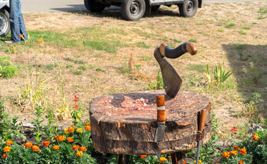 Homemade wooden stand for butchering fresh meat with an ax on the street traditional market