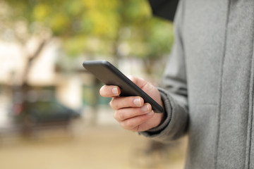 Man hand using a smart phone in winter
