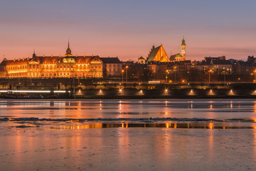 Fototapeta na wymiar Warsaw skyline with the Royal Castle and the Old Town buildings on the Vistula River shore by night. 