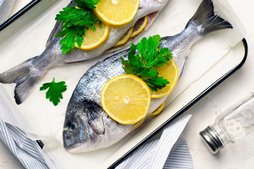 Fresh Dorado or Sea Bream with Lemon and Herbs, Raw Fish Ready to be Cooked, Top View
