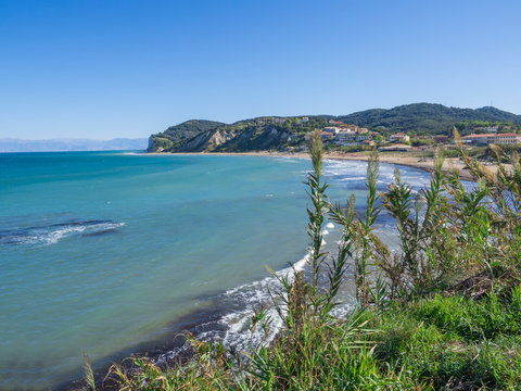View on agios stefanos beach and bay, small tourist resort on the north east coast of Corfu in Greece, summer day blue sky