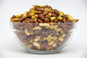 Roasted peanuts in glass bowl on white background