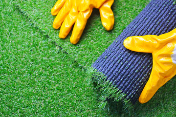 Hand of a worker with a artificial lawn grass. Artificial turf laying background. - obrazy, fototapety, plakaty