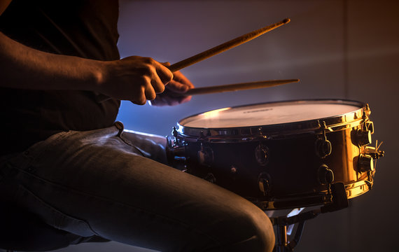 man playing the snare drum on a beautiful colored background