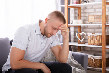 Upset Man Sitting On Sofa