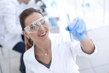 women scientist with test tube making research in clinical laboratory