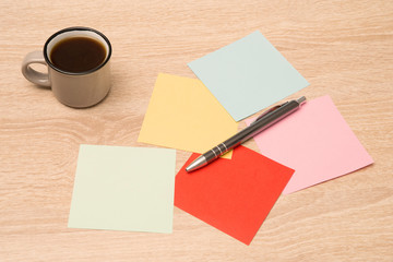 Obraz na płótnie Canvas Writing a note on small papers, wooden table in the background, cup of coffee