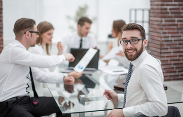 Manager sitting at his Desk and looking at the camera