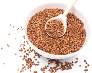 Buckwheat in bowl closeup isolated on white background.