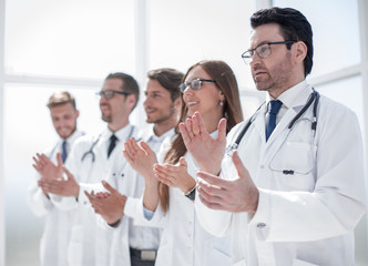 group of doctors applauds, standing in the hospital