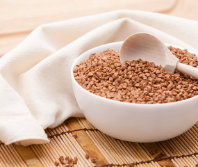 Buckwheat in a white bowl on a wooden table.