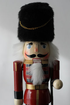 A wooden nutcracker soldier against a white wall