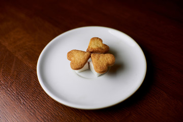 cookies in the shape of hearts lying on a saucer with pieces of sugar