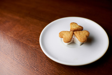 cookies in the shape of hearts lying on a saucer with pieces of sugar