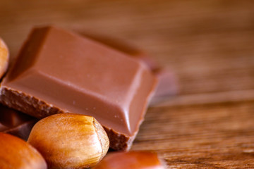 Chocolate and hazelnut on wooden table. Close-up photo with vintage background.