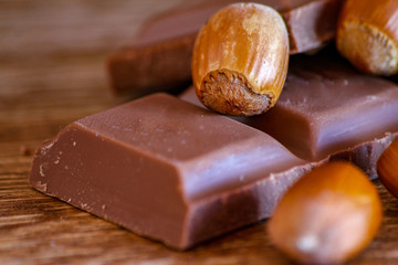 Chocolate and hazelnut on wooden table. Close-up photo with vintage background.