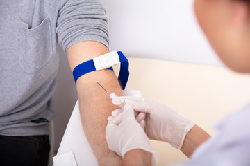 Doctor Injecting Syringe In Patient's Arm