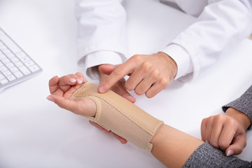 Doctor Checking Fractured Hand Of A Woman