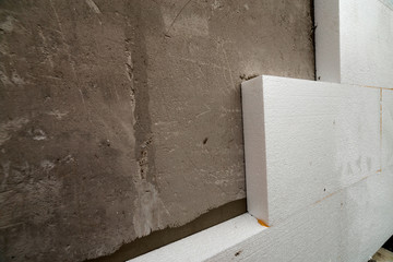 Close-up detail of plastered house wall with rigid styrofoam insulation. Modern technology,...