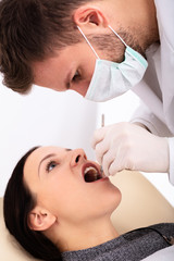 Obraz na płótnie Canvas Dentist Examining Woman's Teeth