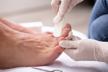 Man Undergoing Pedicure Process In Salon