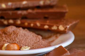 Cocoa, hazelnut and chocolate with hazelnut on wooden table. Close-up photo with vintage background.
