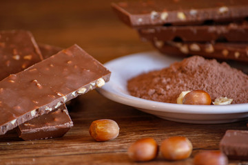 Cocoa, hazelnut and chocolate with hazelnut on wooden table. Close-up photo with vintage background.