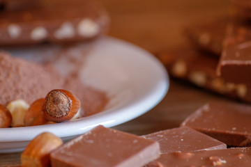Cocoa, hazelnut and chocolate with hazelnut on wooden table. Close-up photo with vintage background.