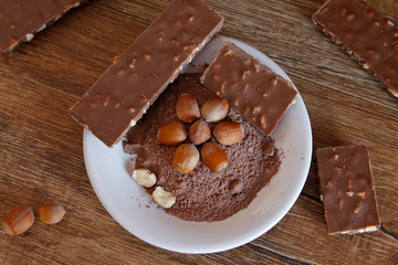 Cocoa, hazelnut and chocolate with hazelnut on wooden table. Close-up photo with vintage background.