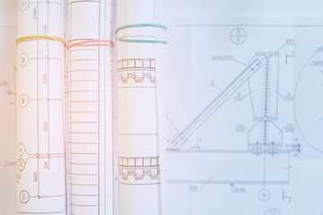 Architectural drawings for the construction of buildings. Rolls of drawings. Selective focus on working drawings. Bright light on the desktop construction engineer.