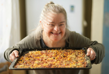 portrait of adult woman with down syndrome holding pizza