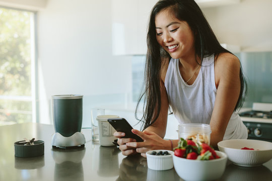 Woman social networking in morning on mobile phone