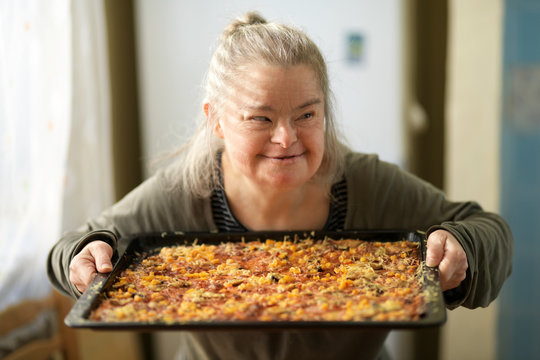 portrait of adult woman with down syndrome holding pizza