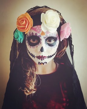 Portrait of a girl with ceremonial sugar skull make-up for Halloween