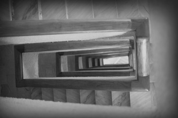 Stair in black and white. The lonely spiral stairs in the hotel to curl deep down. Perspective of...