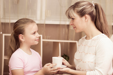 Obraz na płótnie Canvas Loving daughter treating her mother to a mug of coffee