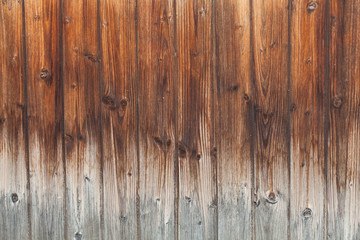Wooden Board background of dark burnt color with gradient in light color. Wooden planks for Your text. Knots on the wooden surface. Vertical strips of natural material in interiors and exteriors.