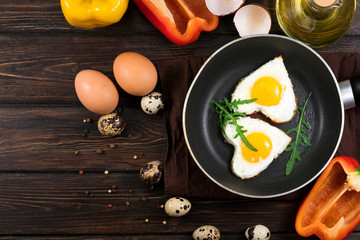 Fried eggs on a skillet on a wooden background